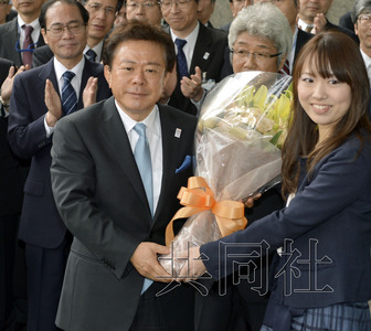 12月18日，高票當選東京都新知事的豬瀨直樹正式到任。圖為豬瀨從政府職員手中接過花束。(共同社)