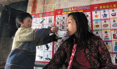 小孫悅為臥床的母親喂飯。 小孫悅為臥床的母親喂飯。